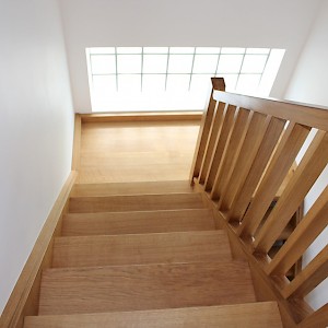 Solid wooden staircase with carpet tread in Suffolk